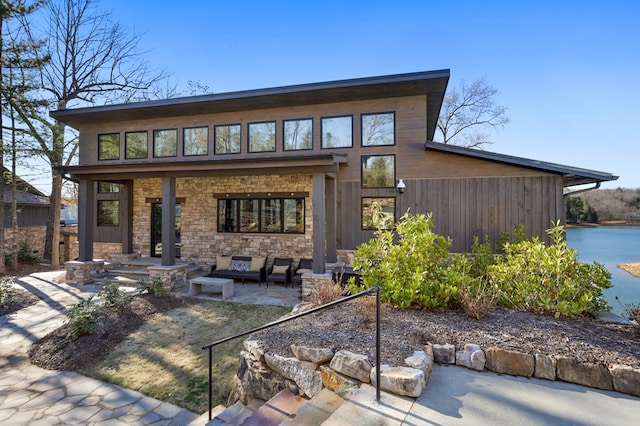 rear view of property with an outdoor living space and a patio area