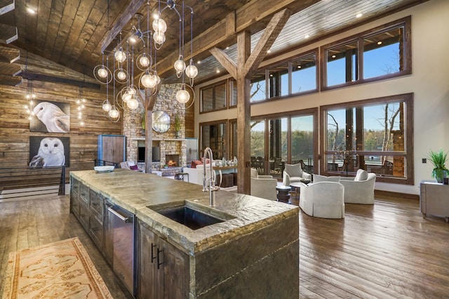 kitchen featuring a center island with sink, high vaulted ceiling, wooden ceiling, and decorative light fixtures