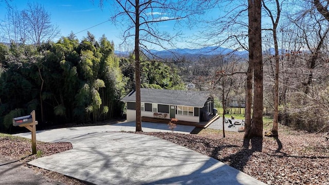 view of front facade featuring driveway and a wooded view