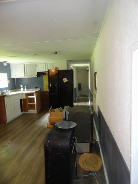 kitchen featuring white cabinets, dark hardwood / wood-style floors, and black fridge with ice dispenser