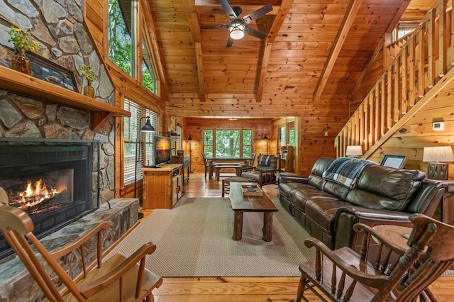 77 Old Covered Bridge Rd, Cherry Log, GA 30522 - living room with high vaulted ceiling, light wood-type flooring, a wood ceiling with exposed beams, a stone fireplace, and ceiling fan
