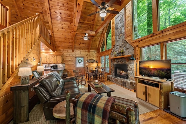 77 Old Covered Bridge Rd, Cherry Log, GA 30522 - living area featuring ceiling fan, a wood ceiling with exposed beams, a stone fireplace, wood walls, and high vaulted ceiling