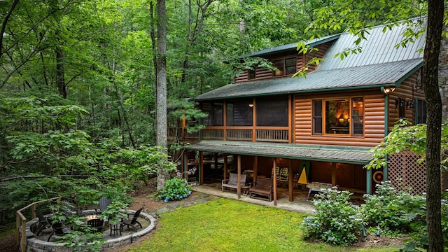 77 Old Covered Bridge Rd, Cherry Log, GA 30522 - back of property featuring a patio area, an outdoor fire pit, faux log siding, a yard, and a sunroom