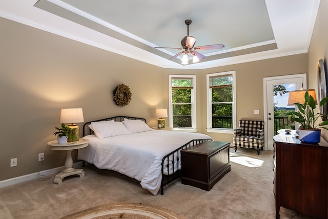 bedroom featuring baseboards, light colored carpet, access to outside, a tray ceiling, and crown molding