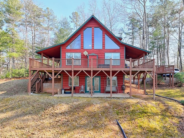 rear view of property featuring stairway, a wooden deck, and a patio