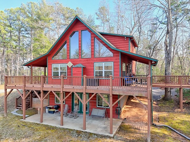 rear view of property featuring a patio and a deck