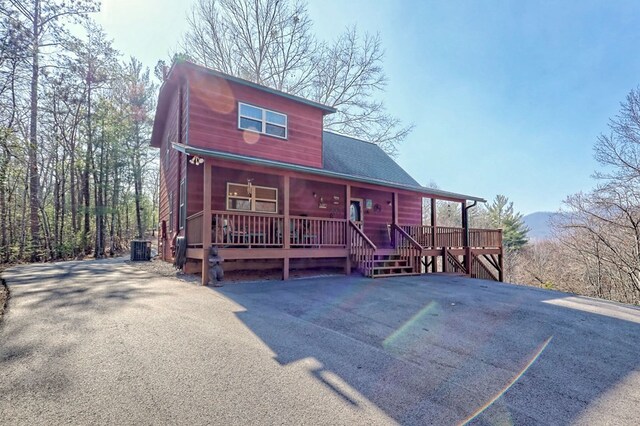 chalet / cabin with central air condition unit and a porch