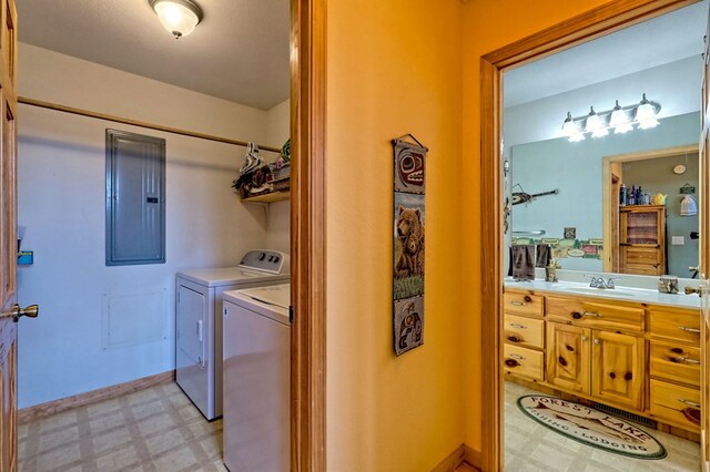 washroom with light floors, laundry area, electric panel, a sink, and independent washer and dryer