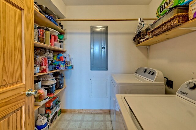 laundry room featuring electric panel, laundry area, washer and dryer, and baseboards