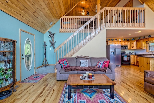 living area featuring stairs, wooden ceiling, light wood finished floors, and high vaulted ceiling