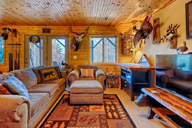 carpeted living area with wooden ceiling and wood walls