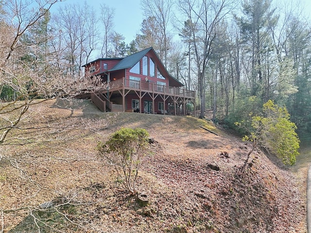 back of house featuring a deck and stairs