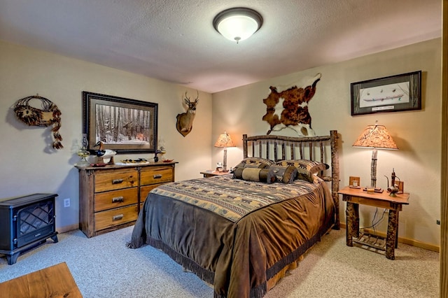 bedroom featuring light colored carpet, baseboards, and a textured ceiling