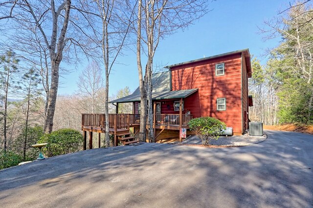 rear view of house with central AC and a wooden deck