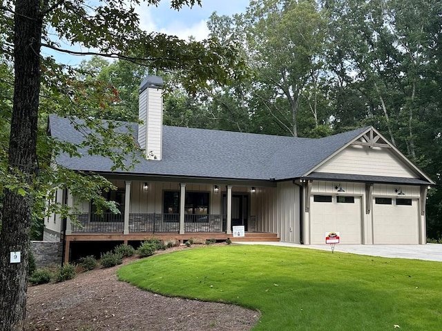 view of front of house featuring a garage, a front yard, and a porch