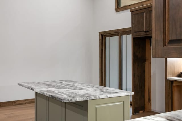 kitchen featuring light stone counters, light hardwood / wood-style flooring, and green cabinetry