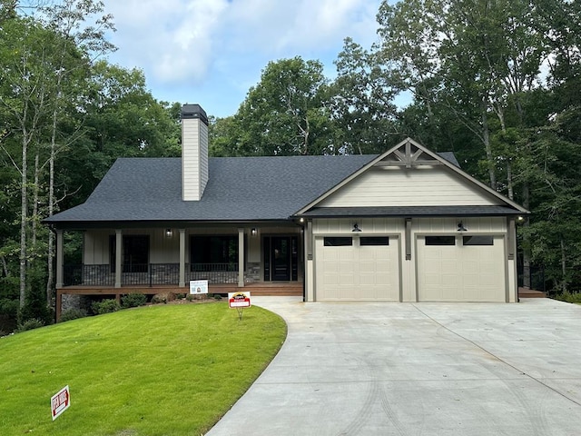 view of front facade with a porch, a garage, and a front yard