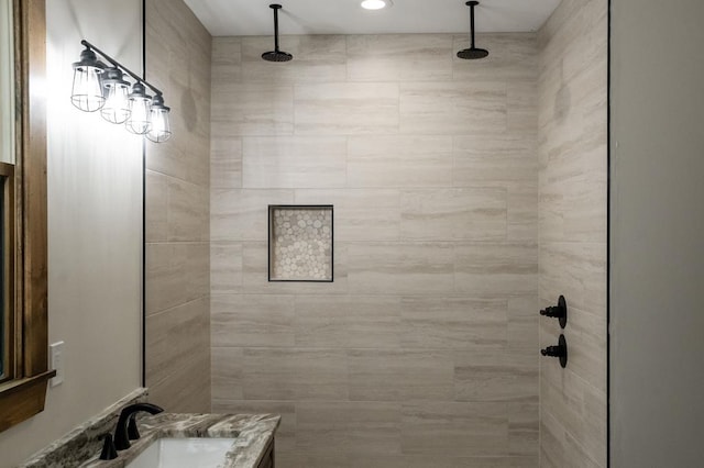 bathroom featuring vanity and tiled shower