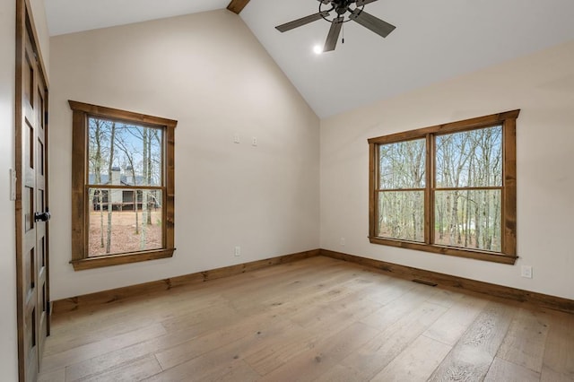 spare room with plenty of natural light, high vaulted ceiling, and light wood-type flooring