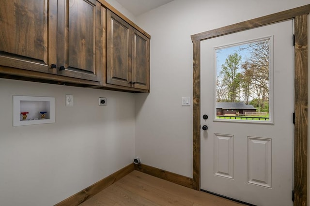 clothes washing area featuring cabinets, washer hookup, hookup for an electric dryer, and light hardwood / wood-style floors