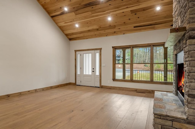 entryway featuring wooden ceiling, a fireplace, high vaulted ceiling, and light wood-type flooring