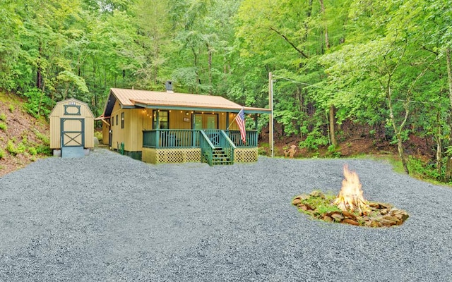 5557 Joe Brown Hwy, Murphy, NC 28906 - view of front facade with a fire pit, covered porch, a view of trees, a chimney, and board and batten siding