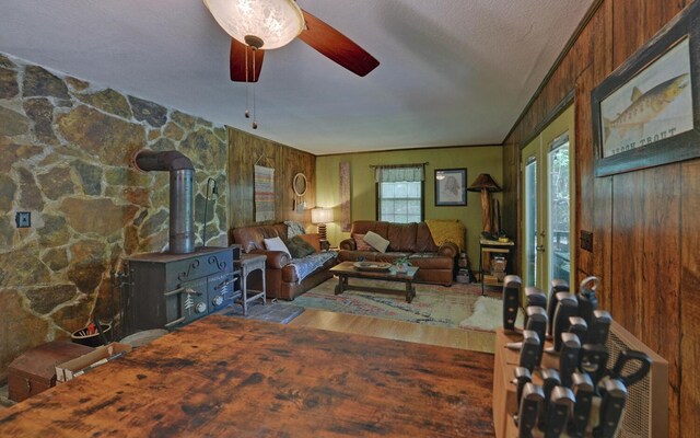 5557 Joe Brown Hwy, Murphy, NC 28906 - living room featuring a wood stove, wood finished floors, a ceiling fan, and wooden walls