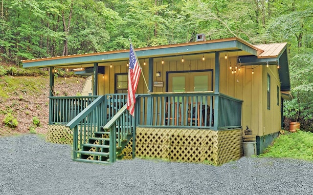 5557 Joe Brown Hwy, Murphy, NC 28906 - view of front of home featuring a porch, board and batten siding, metal roof, and a view of trees