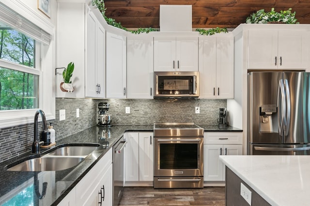 774 Hickory Ridge Dr, Ellijay, GA 30540 - kitchen featuring dark stone counters, white cabinets, tasteful backsplash, a sink, and stainless steel appliances