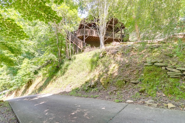 exterior space featuring a forest view and a deck