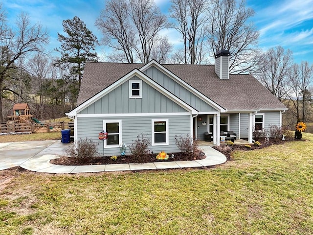 back of property with a yard and a playground