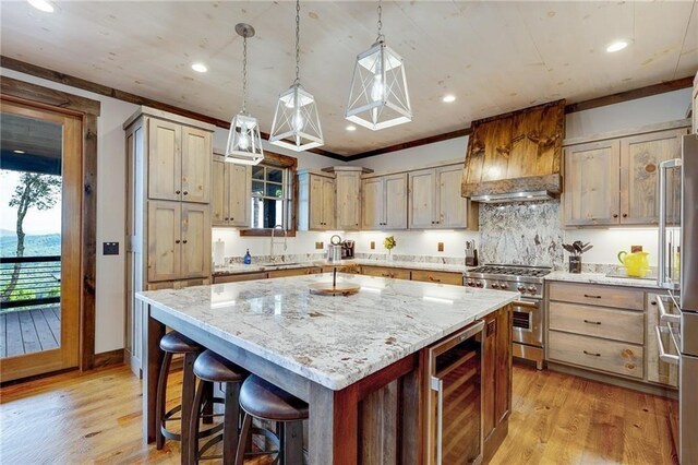 kitchen with beverage cooler, a kitchen island, decorative light fixtures, high end stainless steel range, and premium range hood