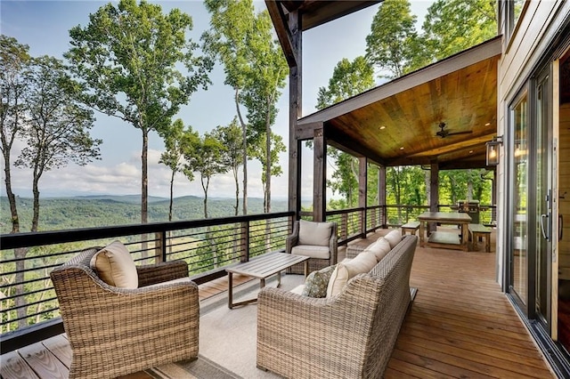 wooden deck featuring a mountain view and an outdoor hangout area