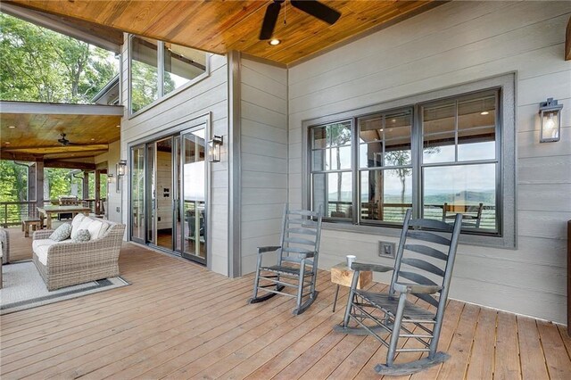 wooden terrace featuring an outdoor living space and a ceiling fan