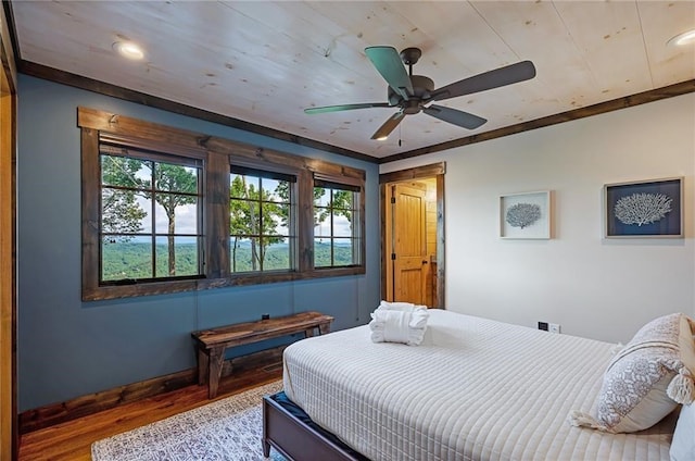 bedroom with ceiling fan, baseboards, wood finished floors, and ornamental molding