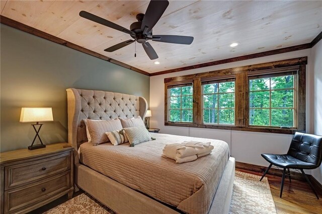 bedroom featuring light wood-type flooring, multiple windows, and crown molding