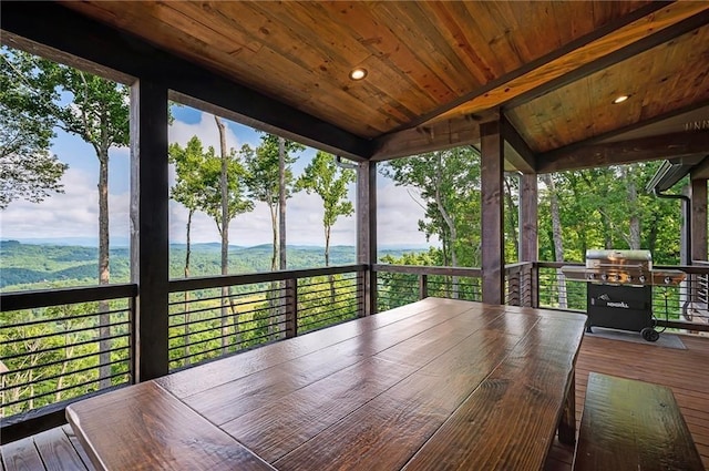 deck with a grill and a mountain view