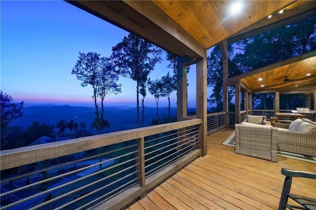 deck at dusk with outdoor lounge area and a mountain view