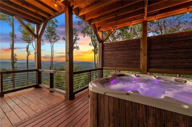 wooden deck with a hot tub and a water and mountain view