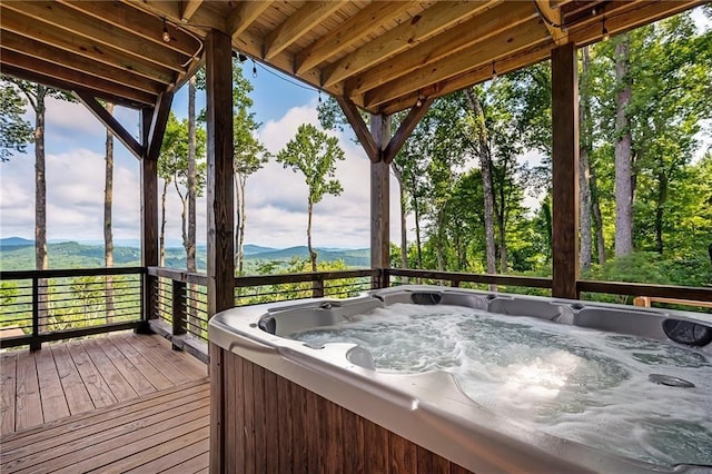 unfurnished sunroom featuring a mountain view and a hot tub