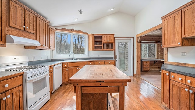 kitchen featuring light wood-style flooring, white appliances, a sink, vaulted ceiling, and range hood