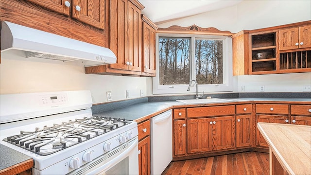 kitchen with extractor fan, white appliances, a sink, vaulted ceiling, and brown cabinetry