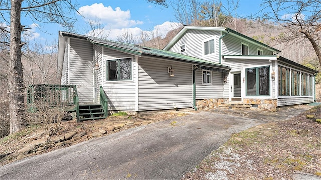 view of front of home with a sunroom and driveway