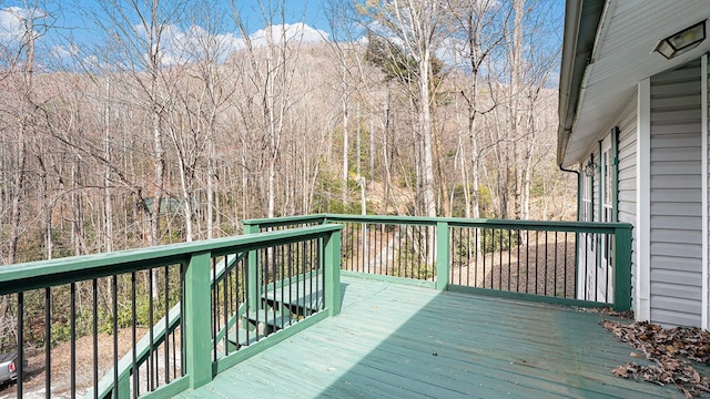 wooden terrace featuring a view of trees