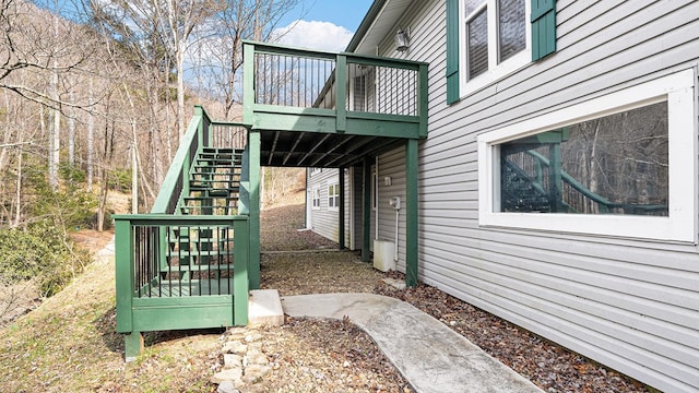 view of side of home featuring stairs and a deck