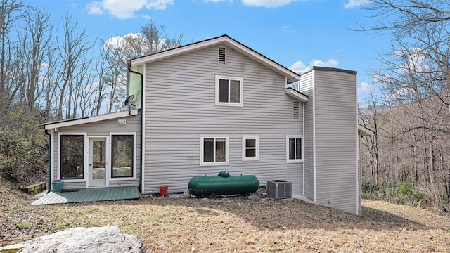 rear view of house featuring a sunroom, central AC unit, and a deck