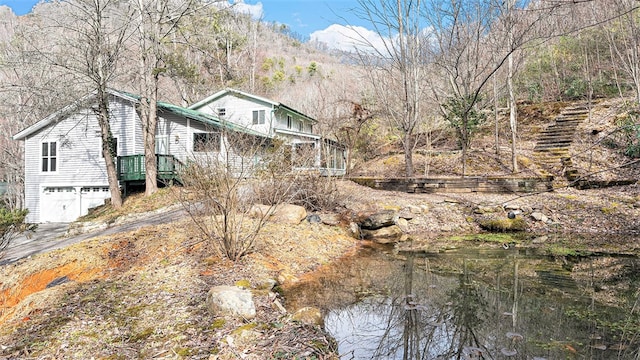 exterior space featuring an attached garage and a view of trees