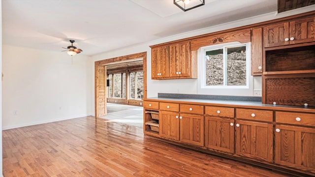 kitchen featuring ceiling fan, brown cabinetry, and wood finished floors