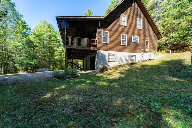 rear view of house with a lawn and a wooden deck