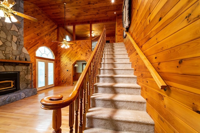 stairway featuring wood walls, high vaulted ceiling, french doors, hardwood / wood-style flooring, and wood ceiling